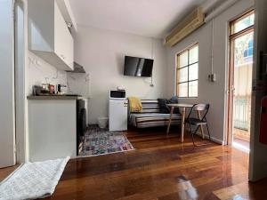 a living room with a couch and a table at Comfortable Studio+free parking for small car in Sydney