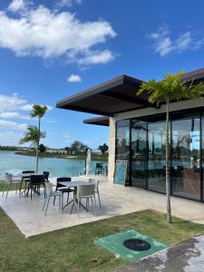 eine Terrasse mit Tischen und Stühlen neben dem Wasser in der Unterkunft Luxury Golf View Penthouse - Pool+Gym+Beach+Fishing in Punta Cana