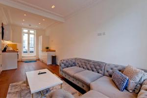 a living room with a couch and a table at 2-Bed Gem near Harrods: Prime Location in London