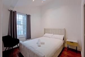 A bed or beds in a room at 2-Bed Gem near Harrods: Prime Location