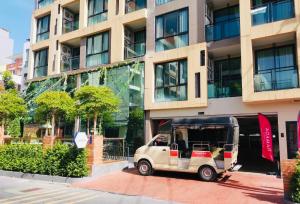 a small car parked in front of a building at Ramada Tenn Ekamai in Bangkok