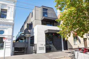 an office building with a black door on a street at Fitzroy North Apartments by Urban Rest in Melbourne