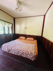 a bedroom with a bed in the corner of a room at Jungle Bangalow Don Det in Muang Không