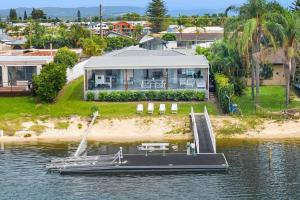 a boat on the water in front of a house at Broadbeach Waterfront home with pool in Gold Coast