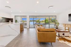 a living room with a couch and a kitchen at Broadbeach Waterfront home with pool in Gold Coast