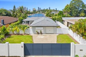 a house with a white fence and a yard at Broadbeach Waterfront home with pool in Gold Coast
