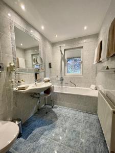 a bathroom with a tub and a sink and a bath tub at Arlen Lodge Appartement in Sankt Anton am Arlberg