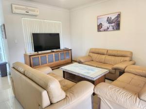 a living room with couches and a flat screen tv at Unit 59 Seafront Estate in Jurien Bay