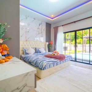 1 dormitorio con cama y ventana grande en BreezyS Pool Villa, en Nong Prue