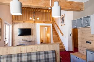 a living room with wood paneling and a staircase at Arlen Lodge Appartement in Sankt Anton am Arlberg