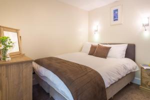 a bedroom with a large bed and a window at Maelfa Crannog Isaf Llangrannog in Llangranog