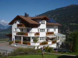 un gran edificio blanco con techo marrón en Haus Venetblick, en Wenns