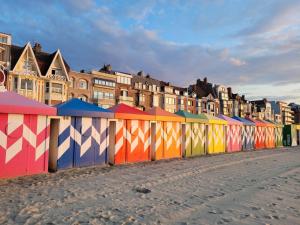 una fila di recinzioni colorate di fronte a un edificio di La Petite Malouine a Dunkerque