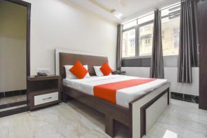 1 dormitorio con 1 cama grande con almohadas de color naranja en Grover International, en Bathinda