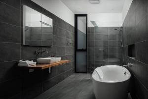 La salle de bains est pourvue d'une baignoire blanche et d'un lavabo. dans l'établissement Blessington Beachside Retreat -38km to CBD, à South Arm