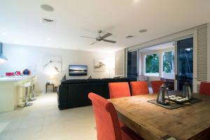 uma sala de estar com uma mesa e um sofá em Whispering Palms - Beachfront Port Douglas em Port Douglas