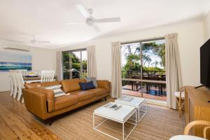 uma sala de estar com um sofá e uma mesa em Surfspray I Pet Friendly I Absolute Beachfront em Culburra Beach