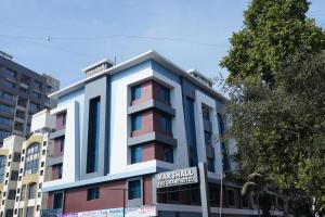 un edificio con una señal delante de él en Marshall The Grand Hotel, en Ahmedabad