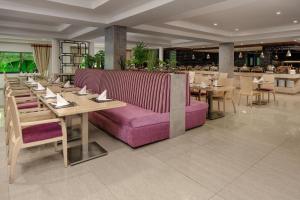 a restaurant with a purple couch and tables and chairs at Delta Hotels by Marriott Dar es Salaam in Dar es Salaam