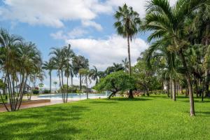 een park met palmbomen en een zwembad bij Delta Hotels by Marriott Dar es Salaam in Dar es Salaam