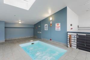 a large swimming pool in the middle of a room at Canberra 1-Bed with Pool, Gym, BBQ & Tennis Court in Canberra