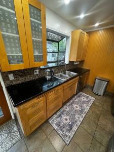 a kitchen with wooden cabinets and a sink and a window at Cozy and Comfy Tree House in Los Angeles