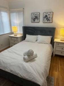 a bedroom with a large white bed with two night stands at Cozy and Comfy Tree House in Los Angeles