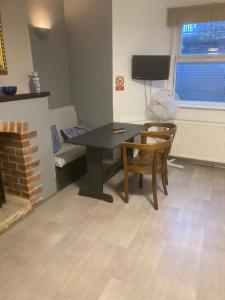 a dining room with a table and chairs and a tv at Abingdon Lodge & Suit in Ryde