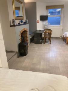 a living room with a fireplace and a desk at Abingdon Lodge & Suit in Ryde