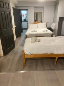 two twin beds in a room with a door at Abingdon Lodge & Suit in Ryde