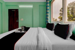 a large bed in a room with green walls at The Kailash Hotel in Jhājra