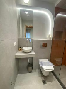 a bathroom with a sink and a toilet and a mirror at City Vibe-Sigrou 44 in Thessaloniki +17 photos
