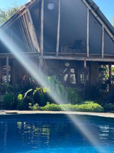 uma casa com um sistema de rega de água junto a uma piscina em Cottage in Arusha-Wanderful Escape em Arusha