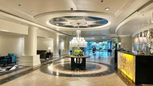 a lobby with a chandelier and a table in it at Grand Regal Hotel Davao in Davao City