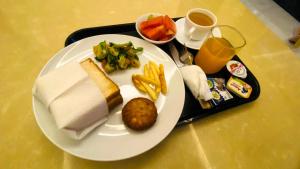a white plate with food on a tray with a meal at One Infinity Residency in kolkata
