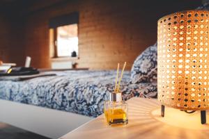 a bottle of oil on a table next to a bed at Kinsau Rooms in Kinsau