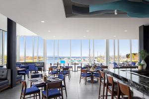 a restaurant with tables and chairs and a view of the water at Delta Hotels by Marriott Thunder Bay in Thunder Bay