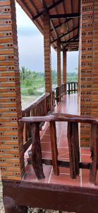 un porche de madera con una mesa de madera en un muelle en Homestay Dream hill en Cat Tien