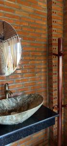 W łazience znajduje się kamienna umywalka i lustro. w obiekcie Homestay Dream hill w mieście Cat Tien