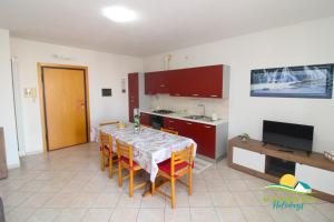 福洛尼卡的住宿－Maremma Holidays: Scogliera Apartment，一间带桌椅的厨房和一间带电视的厨房