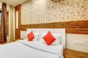 sypialnia z białym łóżkiem z czerwonymi poduszkami w obiekcie OYO Hotel Paris Inn w mieście Hisār