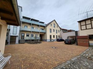 a brick courtyard with a building and a parking lot at Heine`s Hof in Oschersleben