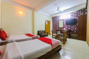a hotel room with two beds and a flat screen tv at Hotel YSM Grand in Tezpur