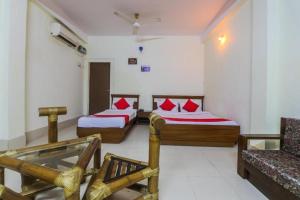 a hotel room with two beds and a couch at Hotel YSM Grand in Tezpur