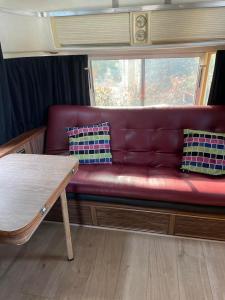 ein rotes Sofa in einem Zimmer mit einem Tisch in der Unterkunft Pooh’s Belle in Grimaud