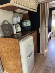 eine Küche mit einem weißen Kühlschrank in einem Wohnwagen in der Unterkunft Pooh’s Belle in Grimaud
