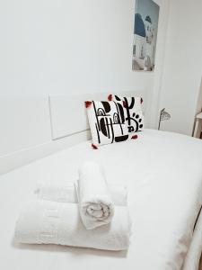 a white bedroom with towels on a bed at Duplex labradores centro 8PAX, PARKING INCLUIDO in Logroño