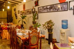 a dining room with a table and chairs and plants at Terrel Residencies Gal Oya in Ampara
