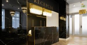 a lobby with a black and gold wall at Hotel Pavco in Gorzów Wielkopolski