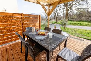 un tavolo nero e sedie su una terrazza in legno di Plaines-Provence Spa&Sauna a Digne-Les-Bains